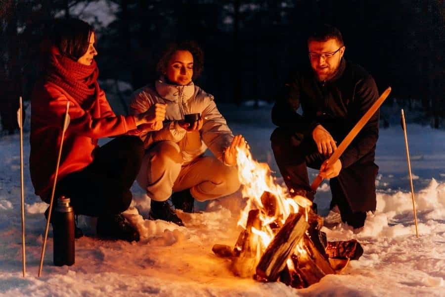 Campers Staying Warm By Campfire